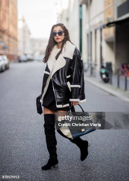 Nadja Ali wearing a Monki sherling jacket, white H&M knit, black mini skirt Zara, black overknees Mint & Berry, Celine bag, Chanel necklace on...