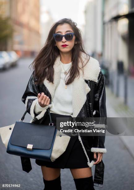 Nadja Ali wearing a Monki sherling jacket, white H&M knit, black mini skirt Zara, black overknees Mint & Berry, Celine bag, Chanel necklace on...