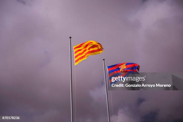 Senyera and FC Barcelona flags flutter during a storm before the La Liga match between FC Barcelona and Sevilla FC at Camp Nou stadium on November 4,...