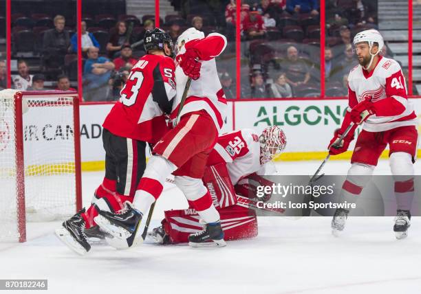 Detroit Red Wings Goalie Jimmy Howard makes a glove save in the first period asOttawa Senators Right Wing Jack Rodewald battles for position in front...