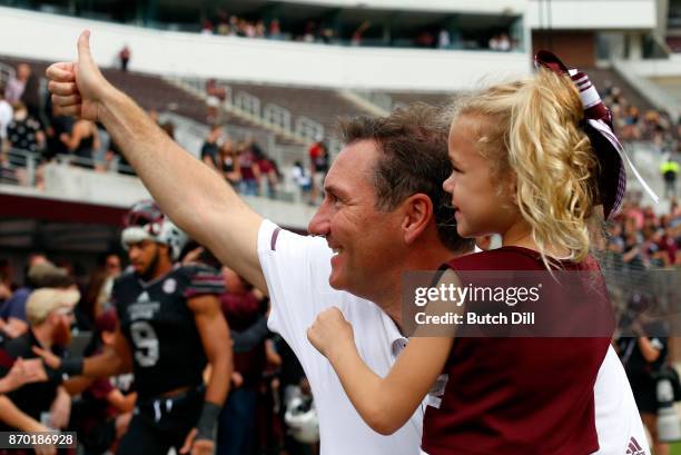 Head coach Dan Mullen of the Mississippi State Bulldogs celebrates with his daughter Breelyn after they defeated the Massachusetts Minutemen 34-23 in...