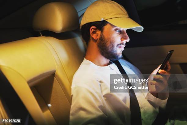 checking some messages on the car ride home - dubai cab stock pictures, royalty-free photos & images