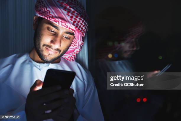 heureusement, discutant avec des amis sur un téléphone - arab teen photos et images de collection