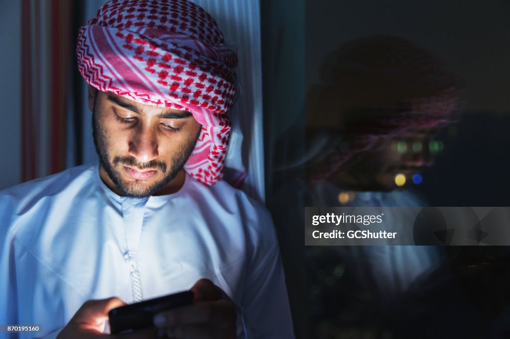 Scrolling the messages of his friend's chatroom on his social media