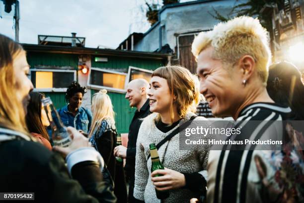 young clubgoers drinking and catching up at open air nightclub - berlin stock-fotos und bilder