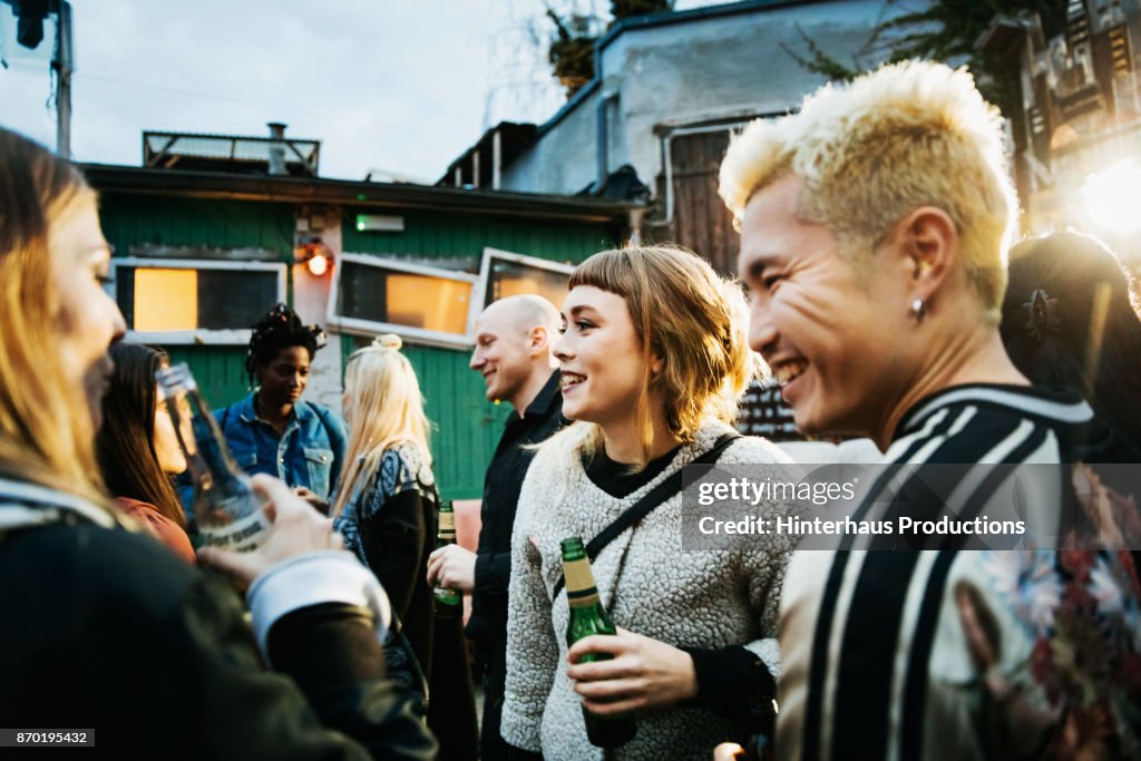 Young Clubgoers Drinking And Catching Up At Open Air Nightclub