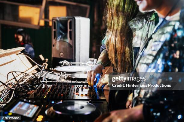 close up of djs working the mixer while performing at nightclub - dj club foto e immagini stock
