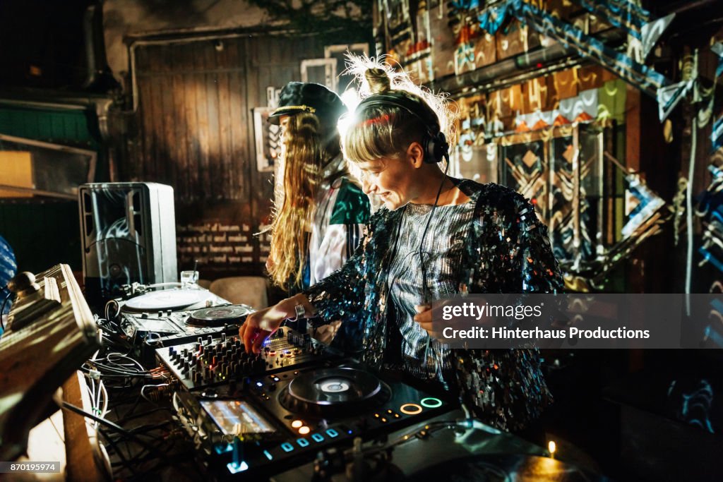 Two Stylish DJs Smiling While Performing together At Open Air Nightclub