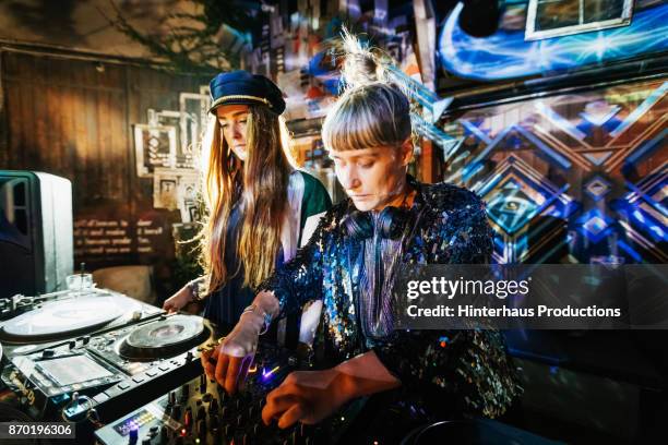 two stylish djs performing at colourful open air nightclub - dj fotografías e imágenes de stock