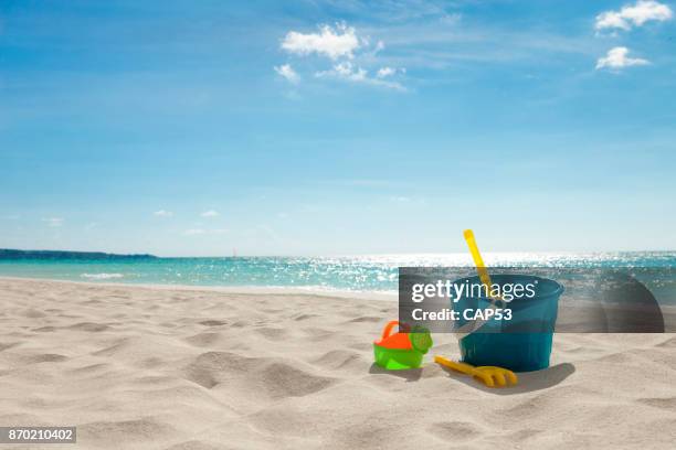 spielzeug für den strand im sand - bucket stock-fotos und bilder