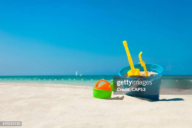 spielzeug für den strand im sand - bucket stock-fotos und bilder