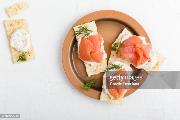 crackers with smoked salmon - smoked stock pictures, royalty-free photos & images