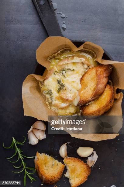 baked cheese with garlic and rosemary in cast iron skillet - camambert bildbanksfoton och bilder