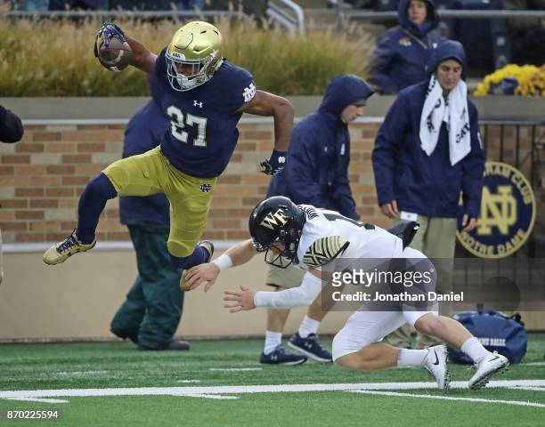 Julian Love of the Notre Dame Fighting Irish is knocked out of bound by John Wolford of the Wake Forest Demon Deacons after an interception at Notre...