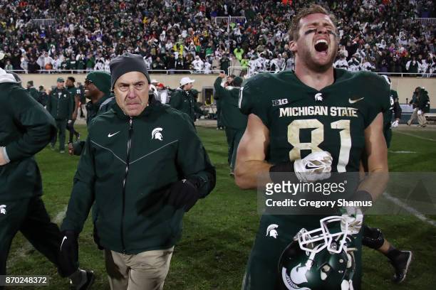 Matt Sokol of the Michigan State Spartans celebrates a 27-24 win over the Penn State Nittany Lions next to head coach Mark Dantonio at Spartan...