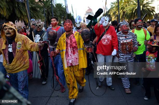 People dressed up like zombies participate in the so-called "Zombie Walk" in Mexico City on November 4, 2017. Hundreds of people take the streets of...