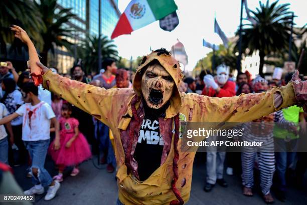 People dressed up like zombies participate in the so-called "Zombie Walk" in Mexico City on November 4, 2017. Hundreds of people take the streets of...