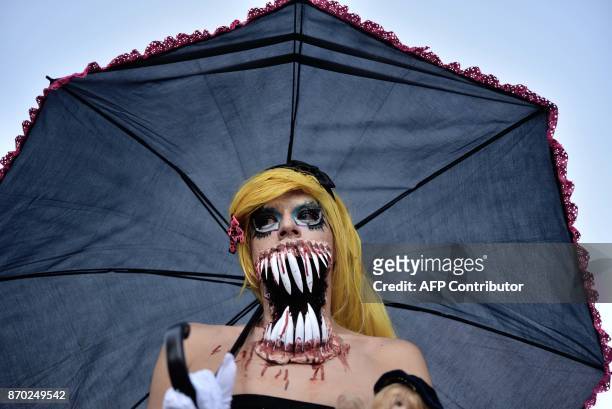 People dressed up like zombies participate in the so-called "Zombie Walk" in Mexico City on November 4, 2017. Hundreds of people take the streets of...