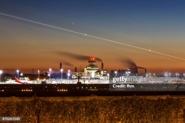 airport berlin-tegel (txl) at sunset with lights of a landing aircraft - (berlin-reinickendorf, germany) - tegel airport in berlin stock-fotos und bilder