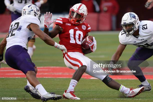 Wide receiver JD Spielman of the Nebraska Cornhuskers tries to avoid the tackle from defensive back Alonzo Mayo of the Northwestern Wildcats and...