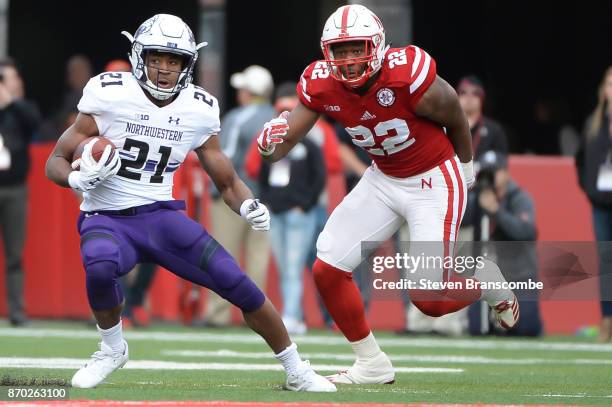 Running back Justin Jackson of the Northwestern Wildcats runs from linebacker Alex Davis of the Nebraska Cornhuskersat Memorial Stadium on November...