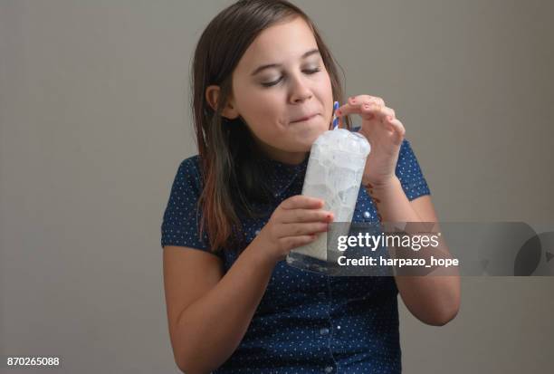 girl holding glass of milk with bubbles. - harpazo hope stock pictures, royalty-free photos & images