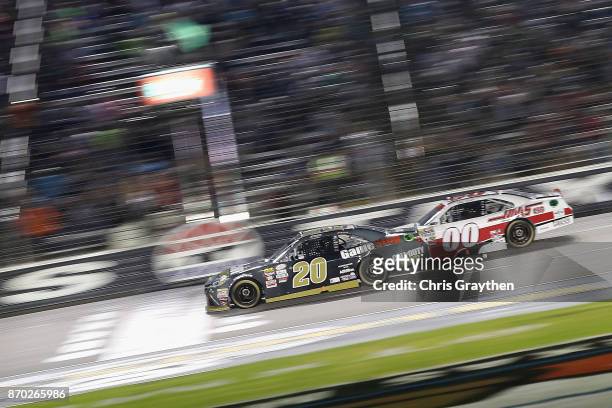 Erik Jones, driver of the GameStop/Call of Duty WWII Toyota, leads Cole Custer, driver of the Haas Automation Ford, past the green flag to start the...