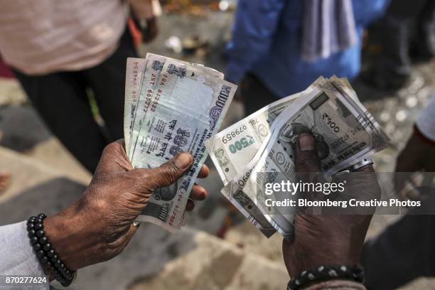 a man counts indian rupee banknotes - indian currency stock-fotos und bilder