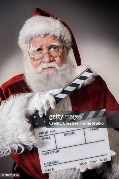 grumpy santa claus holding a film clapperboard - christmas truce 個照片及圖片檔