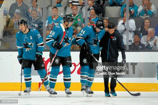 Marc-Edouard Vlasic of the San Jose Sharks is assisted off the ice by Head athletic trainer, Ray Tufts after getting boarded by Ryan Johansen of the...