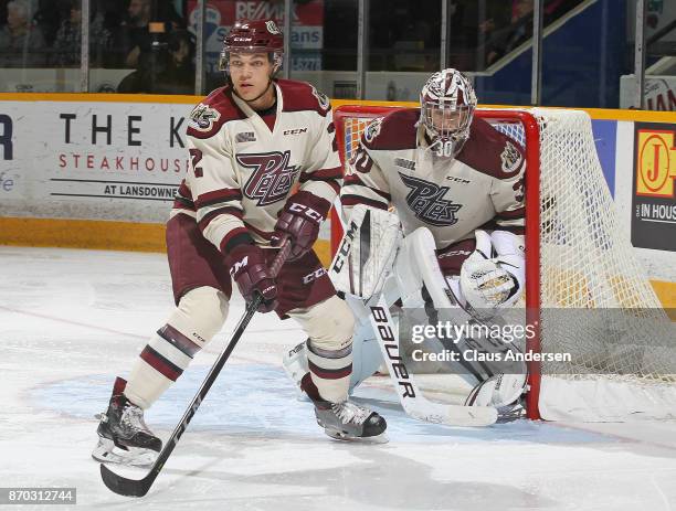 Cole Fraser of the Peterborough Petes defends against the Barrie Colts during an OHL game at the Peterborough Memorial Centre on November 4, 2017 in...