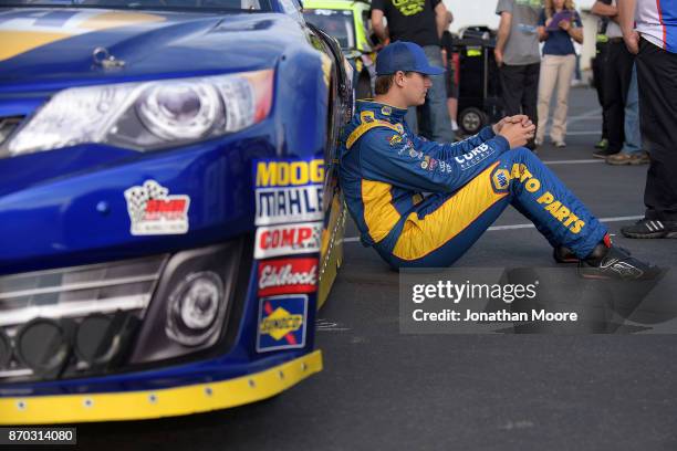Todd Gilliland, driver of the NAPA Auto Parts Toyota, sits next to his car during qualifying for the NASCAR K&N Pro Series West Coast Stock Car Hall...