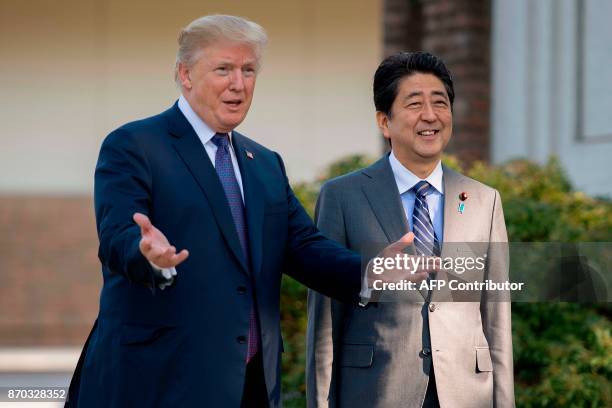 President Donald Trump gestures as he speaks with Japan's Prime Minister Shinzo Abe upon arrival for a luncheon at the Kasumigaseki Country Club Golf...