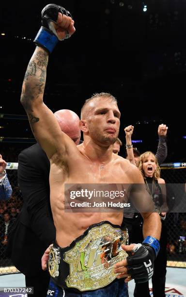 Dillashaw accepts his championship belt after defeating Cody Garbrandt in their UFC bantamweight championship bout during the UFC 217 event at...