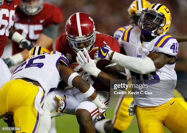 Bo Scarbrough of the Alabama Crimson Tide is tackled by John Battle and Devin White of the LSU Tigers at Bryant-Denny Stadium on November 4, 2017 in...