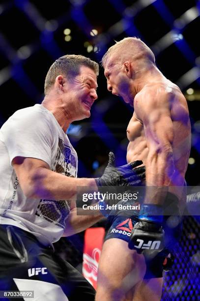 Dillashaw celebrates with a trainer after defeating Cody Garbrandt in their UFC bantamweight championship bout during the UFC 217 event at Madison...