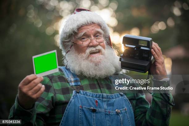 joyful santa claus showing a photo taken with an instant camera - the forest photocall ストックフォトと画像