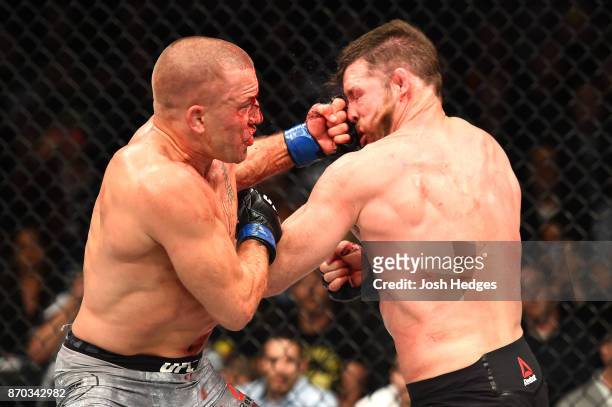 Georges St-Pierre of Canada lands a punch to take down Michael Bisping of England in their UFC middleweight championship bout during the UFC 217...