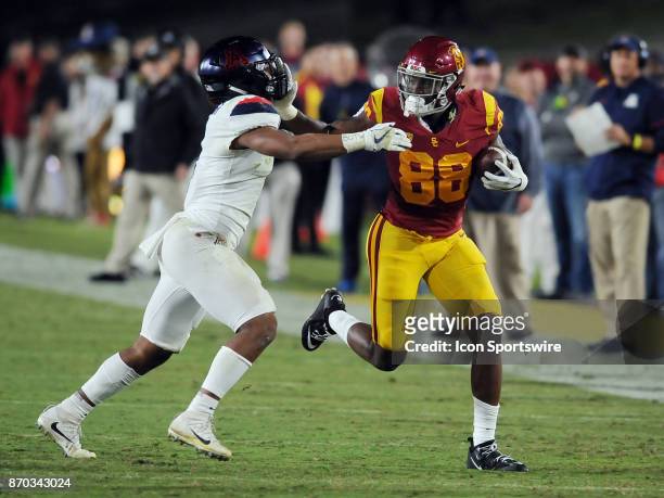 Trojans tight end Daniel Imatorbhebhe straight arms Arizona Wildcats linebacker Tony Fields II after Imatorbhebhe gained yards on a pass in the...