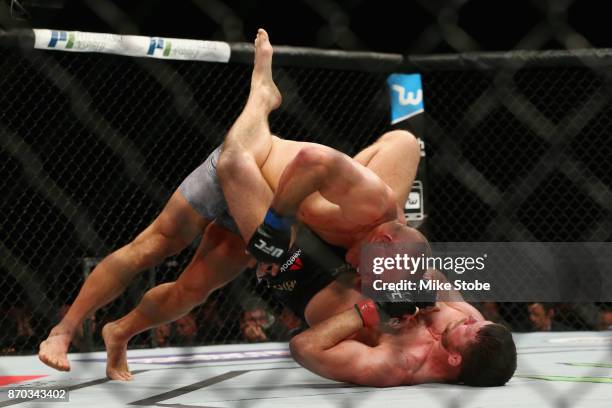 Georges St-Pierre of Canada brings down Michael Bisping of England in their UFC middleweight championship bout during the UFC 217 event at Madison...