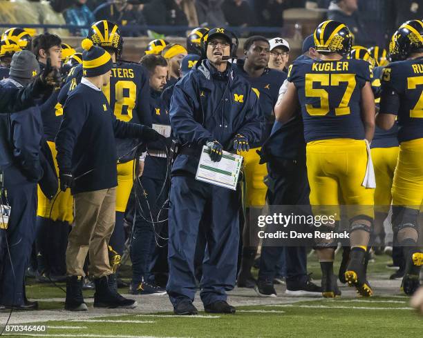Head coach Jim Harbaugh of the Michigan Wolverines looks up at the score board during a college football game against the Minnesota Golden Gophers at...