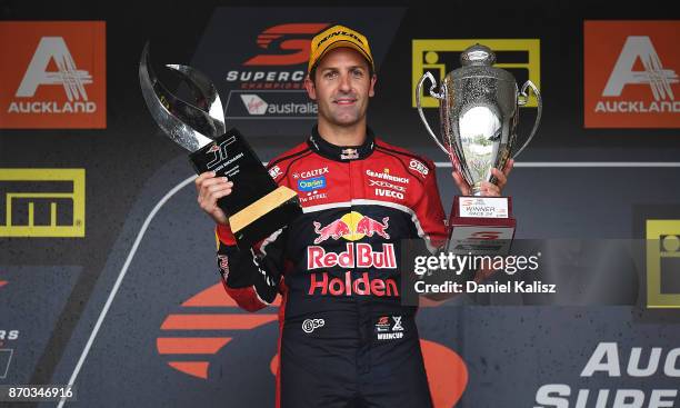 Race winner Jamie Whincup driver of the Red Bull Holden Racing Team Holden Commodore VF holds the winning tropy and the Jason Richards memorial...