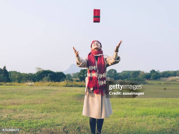 cheerful woman throwing gift box in the air - gift box tag stock-fotos und bilder