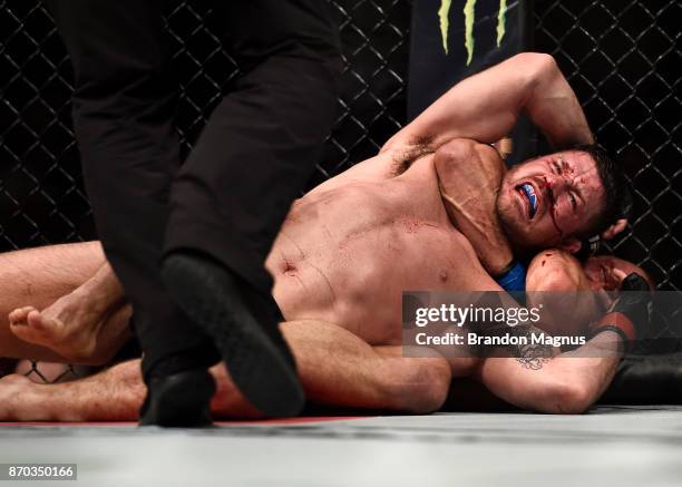 Georges St-Pierre of Canada attempts to submit Michael Bisping of England in their UFC middleweight championship bout during the UFC 217 event inside...