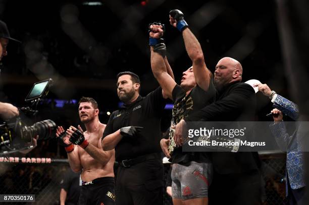 Georges St-Pierre of Canada celebrates his submission victory over Michael Bisping of England in their UFC middleweight championship bout during the...