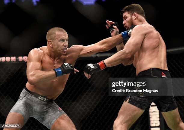 Georges St-Pierre of Canada punches Michael Bisping of England in their UFC middleweight championship bout during the UFC 217 event inside Madison...