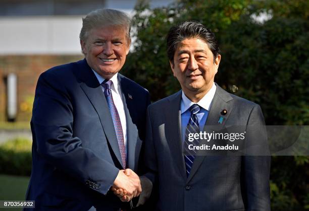 President Donald Trump shakes hands with Japanese Prime Minister Shinzo Abe upon his arrival at the Kasumigaseki Country Club in Kawagoe, near Tokyo,...