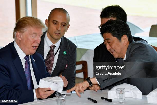 President Donald Trump and Japanese Prime Minister Shinzo Abe sign hats reading 'Donald and Shinzo, Make Alliance Even Greater' at the Kasumigaseki...