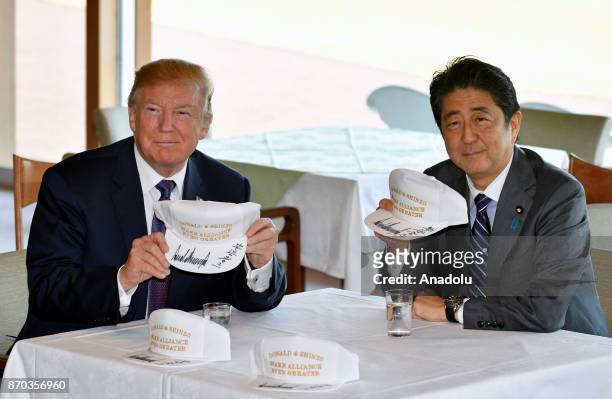 President Donald Trump and Japanese Prime Minister Shinzo Abe pose after they signed hats reading 'Donald and Shinzo, Make Alliance Even Greater' at...