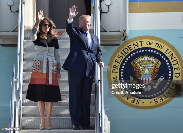 President Donald Trump and his wife Melania Trump wave as they arrive at Yokota Air Base in Tokyo, Japan on November 5, 2017.